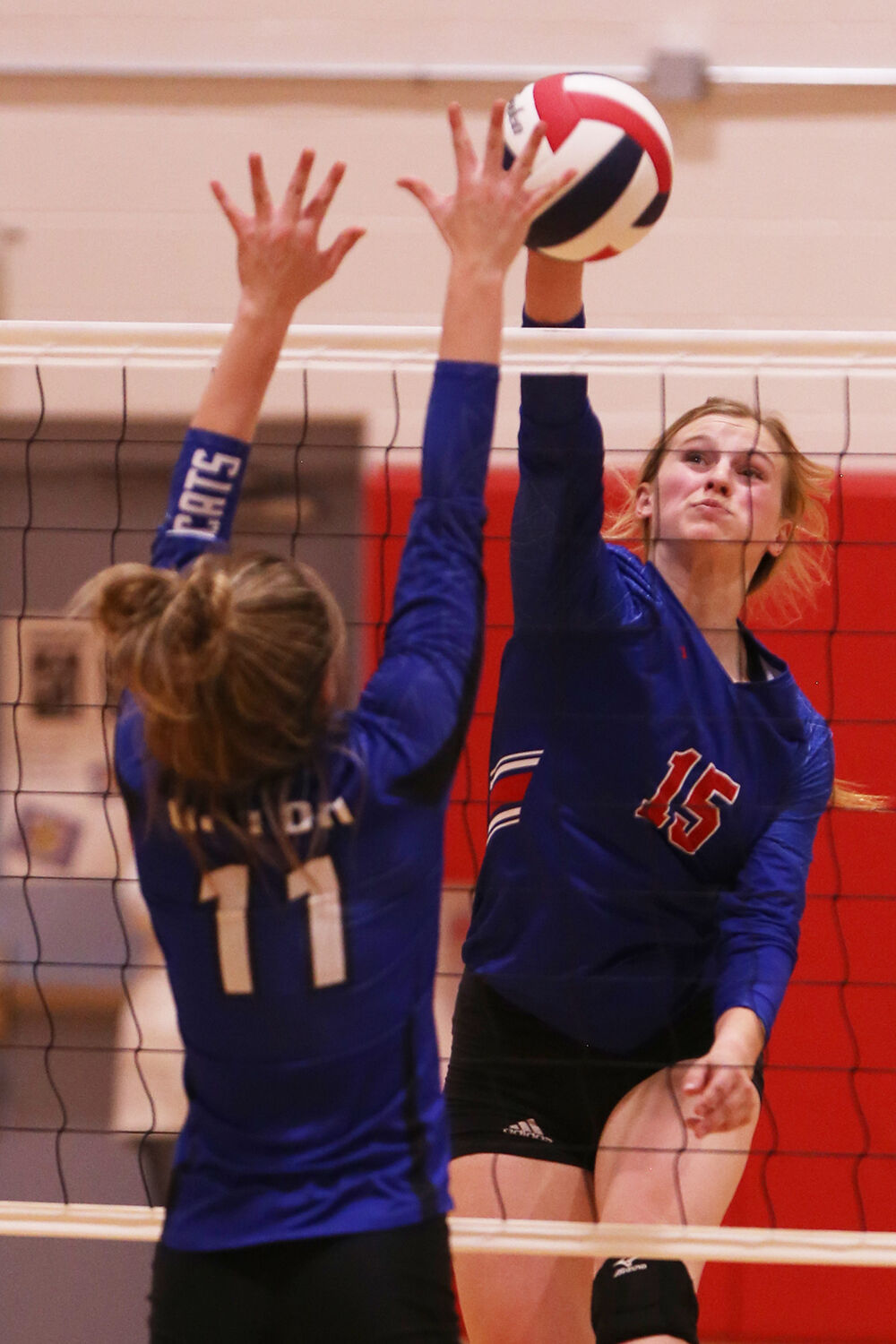 Tinley Pierson hits the ball by the hands of Upton middle blocker Jerrica Caylor